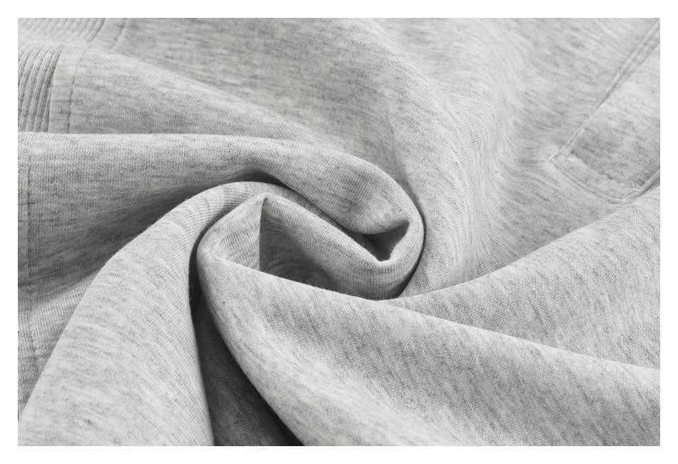 Close-up of heather-gray garment fabric gathered into folds to show its drape.
