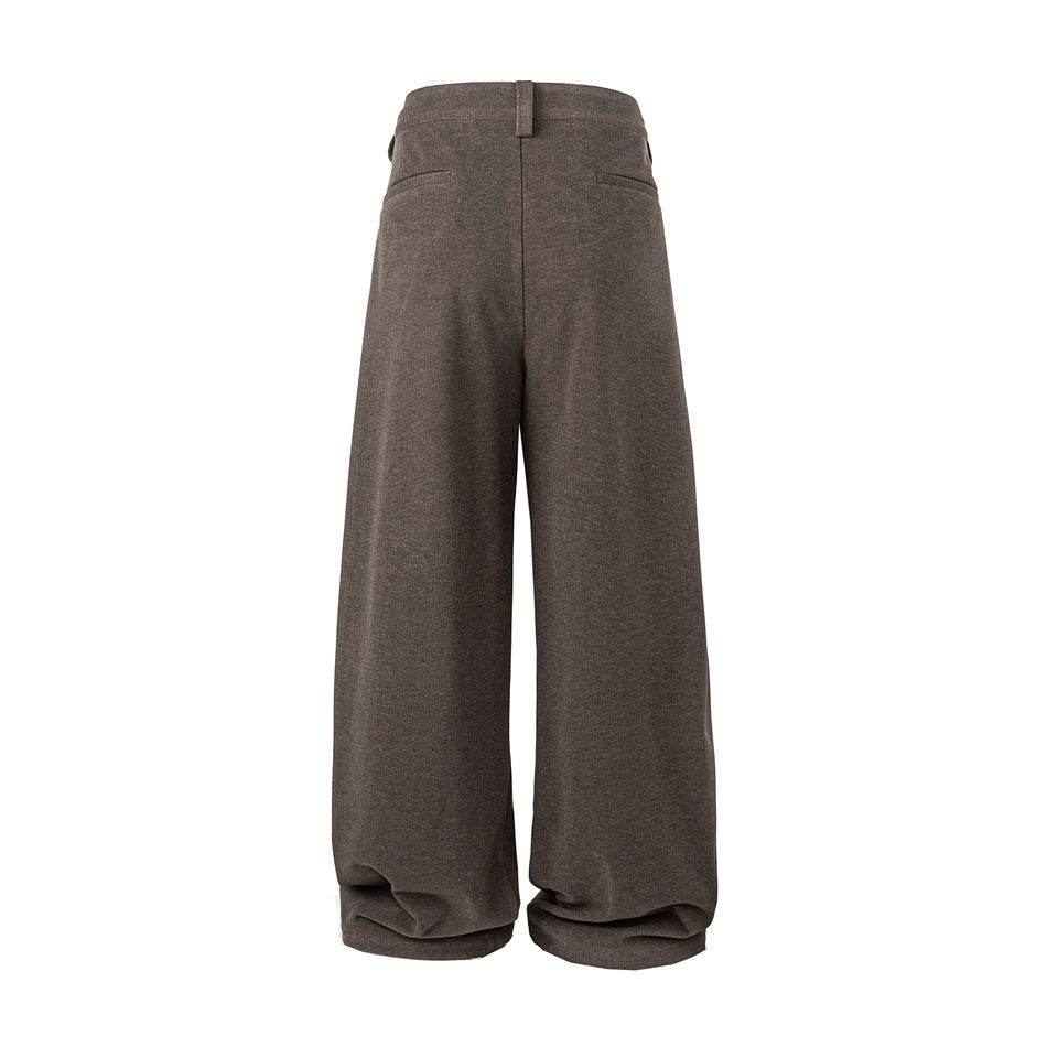 Back view of brown wide-leg trousers with two welt pockets and a center seam.