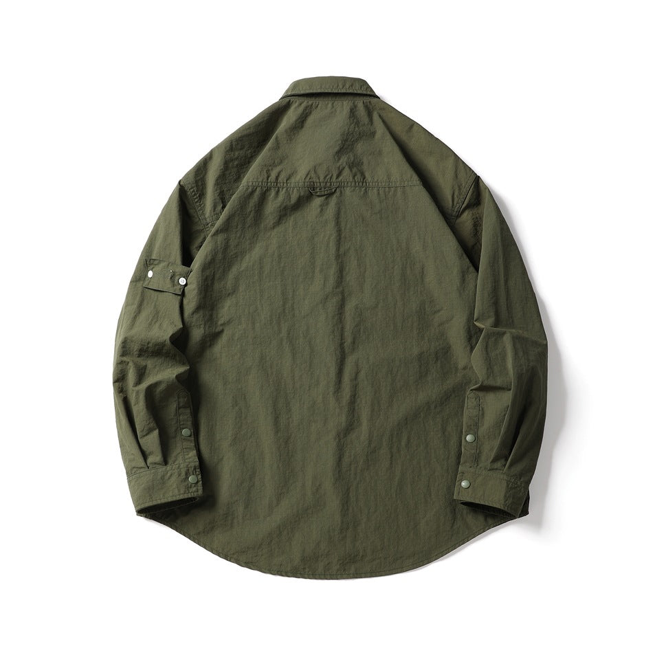 Back view of a dark olive long-sleeve shirt with a pointed collar, curved hem, and snap-button cuffs.