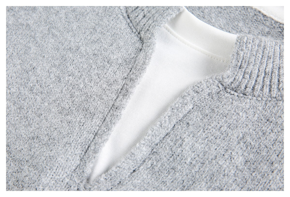 Detail of a light gray knit sweater showing the white inner neckline and ribbed collar trim.