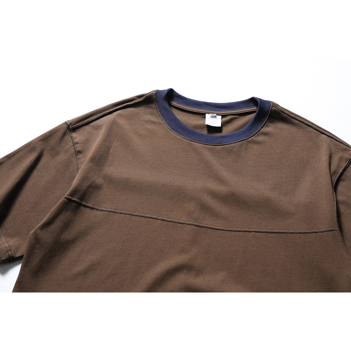 Close-up of a brown short-sleeve T-shirt front with a navy ribbed crew neck and horizontal chest seam.