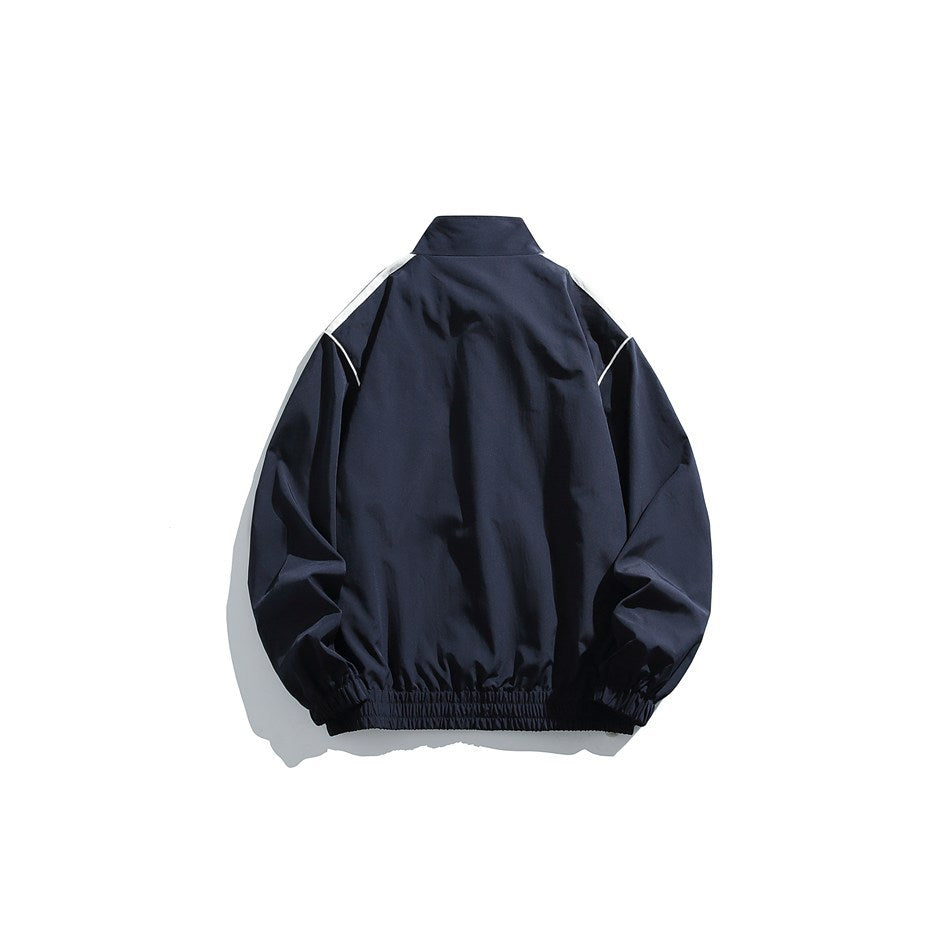 Navy track jacket back view with stand collar, white shoulder panels, white piping and elastic cuffs and hem