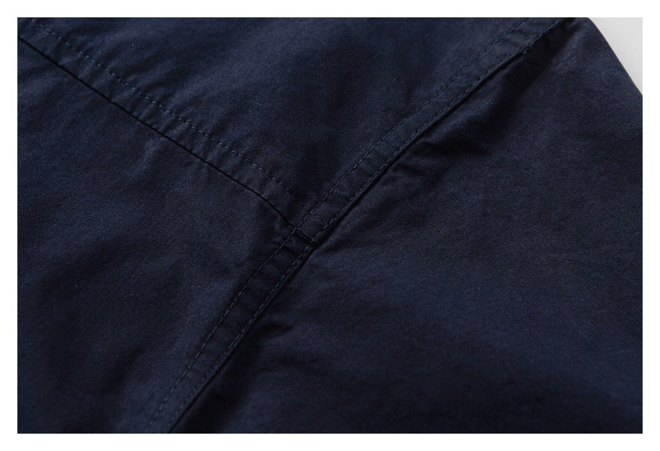 Close-up of intersecting stitched seams on a navy garment.