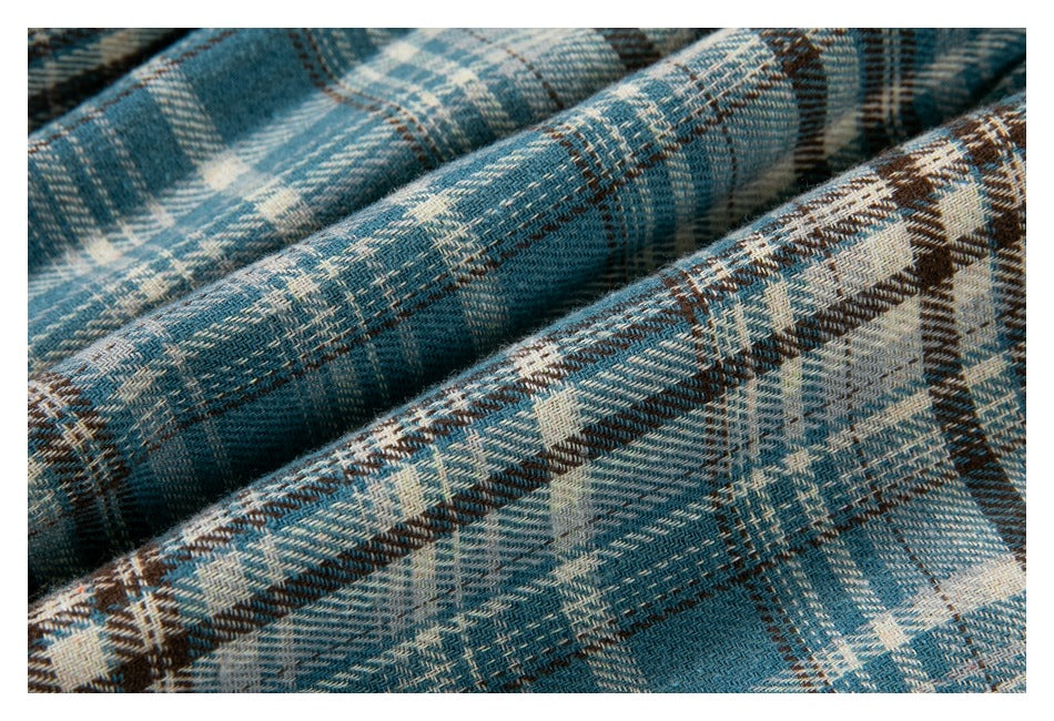 Close-up of blue, cream, and brown plaid fabric showing its woven pattern.