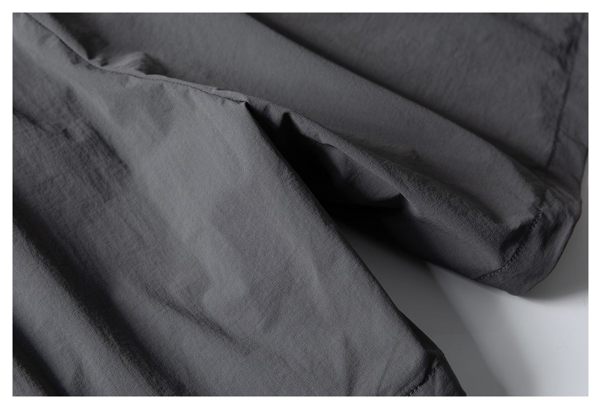 Close-up of charcoal shorts fabric and a stitched hem.