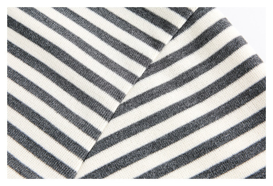 Close-up of cream and charcoal horizontal stripes meeting at an angled seam on a knit garment.