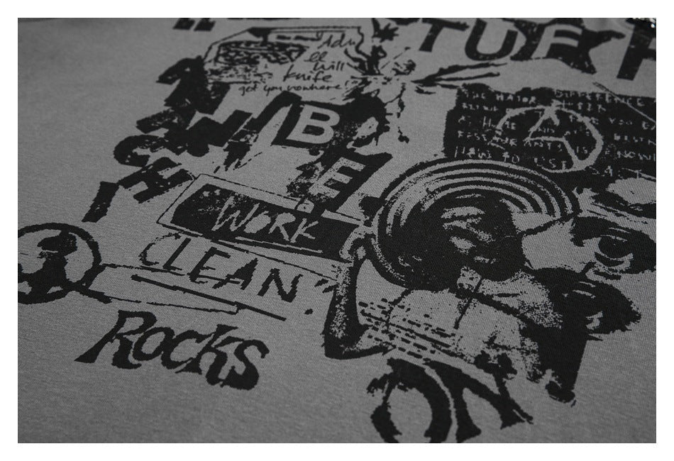 Tight view of distressed black English lettering and graphic artwork printed on gray fabric.