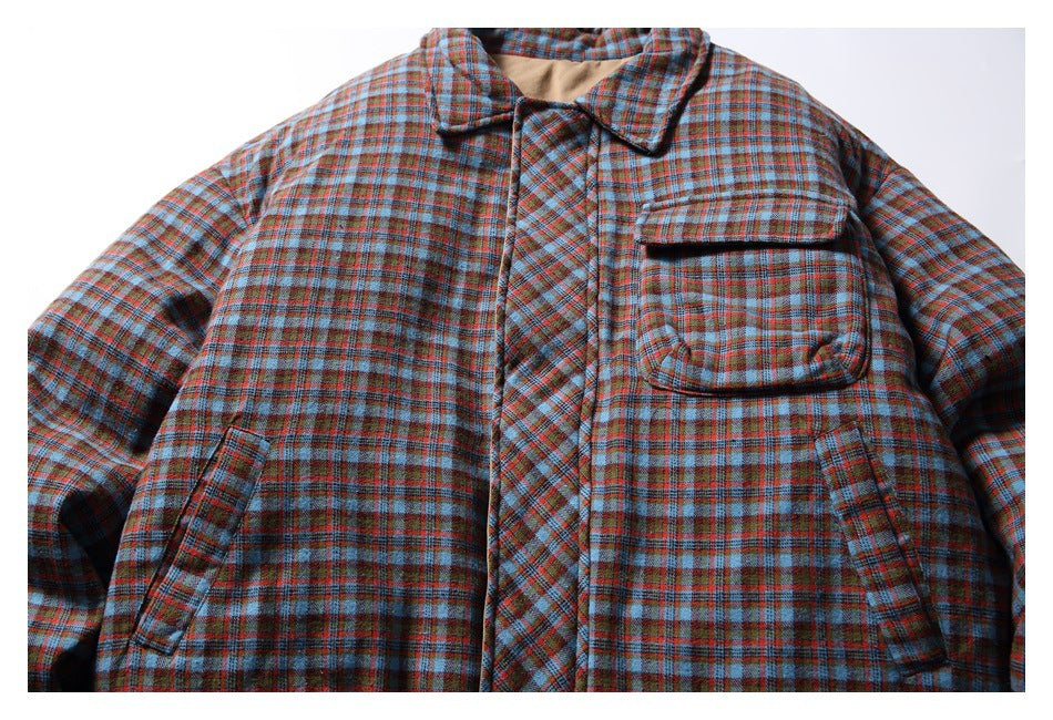 Front view of a blue, rust and brown plaid jacket with a large flap chest pocket and angled side pockets.