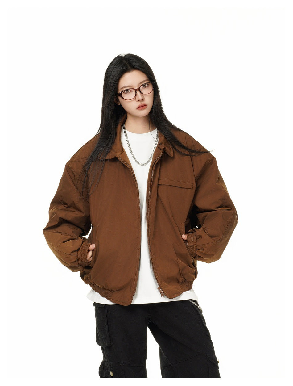 Model wearing an open brown zip-front jacket with a chest pocket, elastic cuffs, and gathered hem.