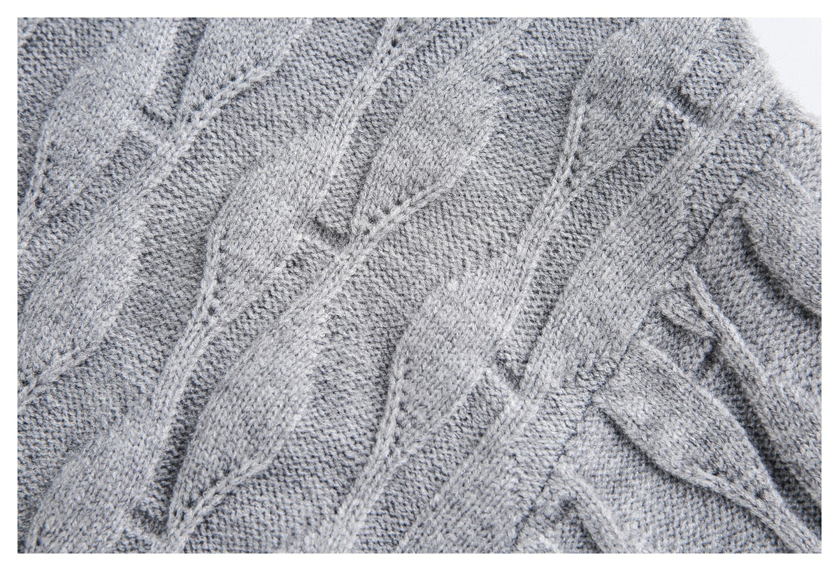 Close-up of the gray sweater's raised cable-knit pattern and textured stitches.