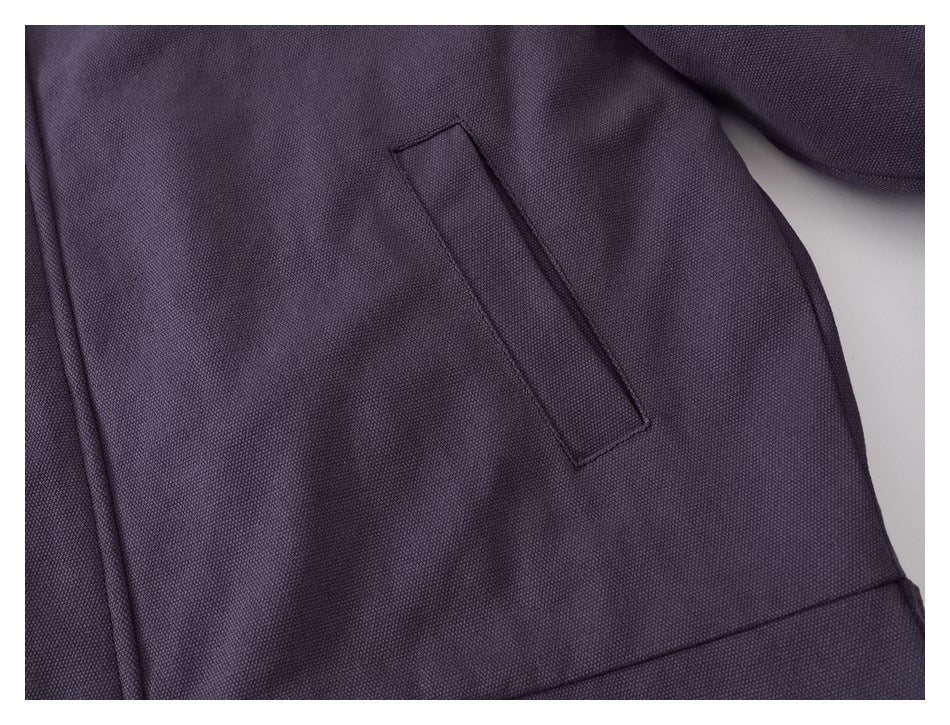 Close-up of a slanted welt pocket on the purple jacket.