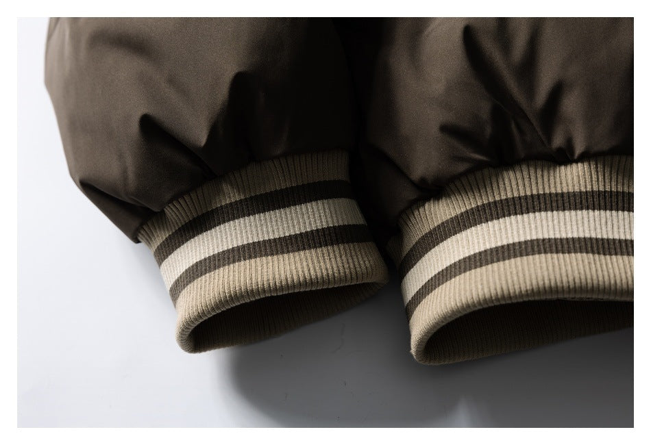 Close-up of the dark brown jacket's sleeves and beige ribbed cuffs with black stripes.