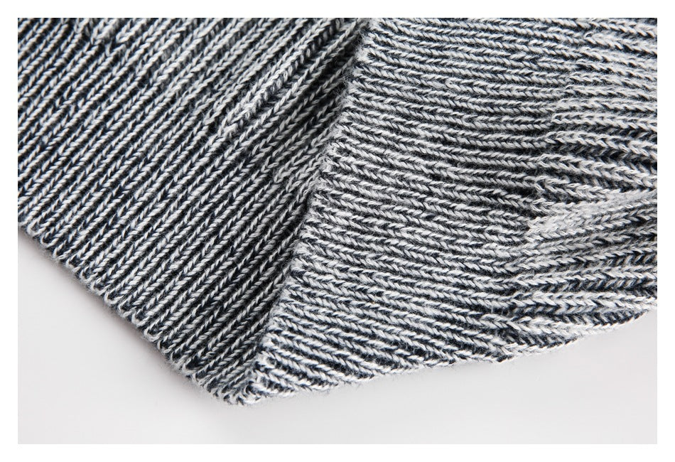 Close-up of black and white rib-knit fabric showing a joined seam and folded edge.