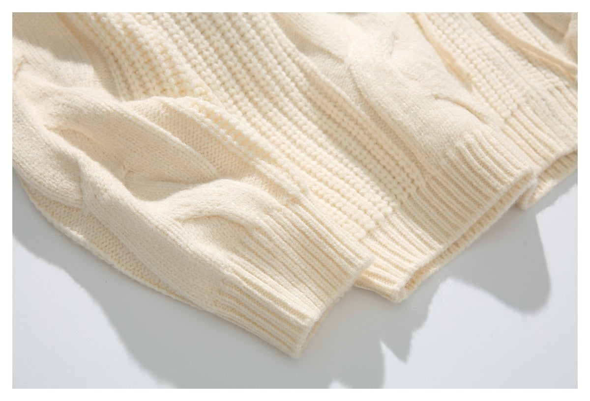 Close-up of the cream sweater's textured knit and ribbed sleeve cuff and hem.