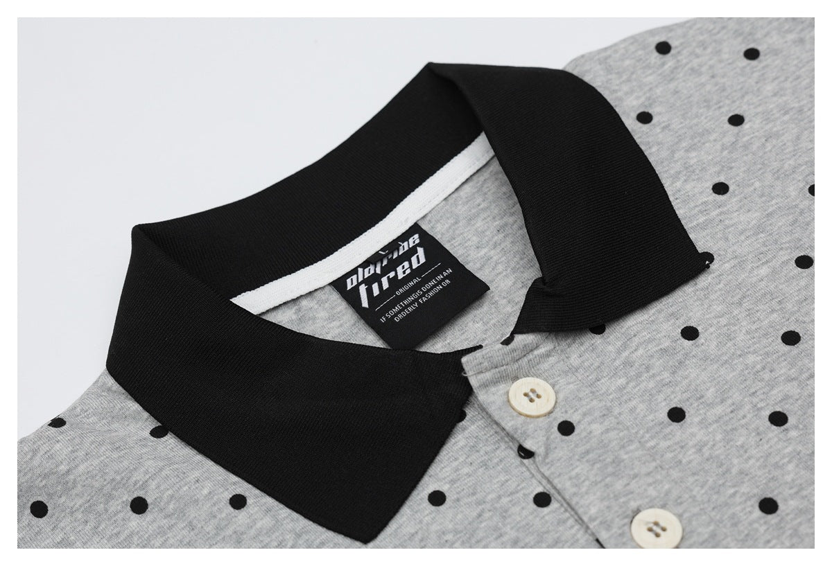 Close-up of a gray black-dotted shirt with a black collar, cream buttons, and a sewn-in neck label.
