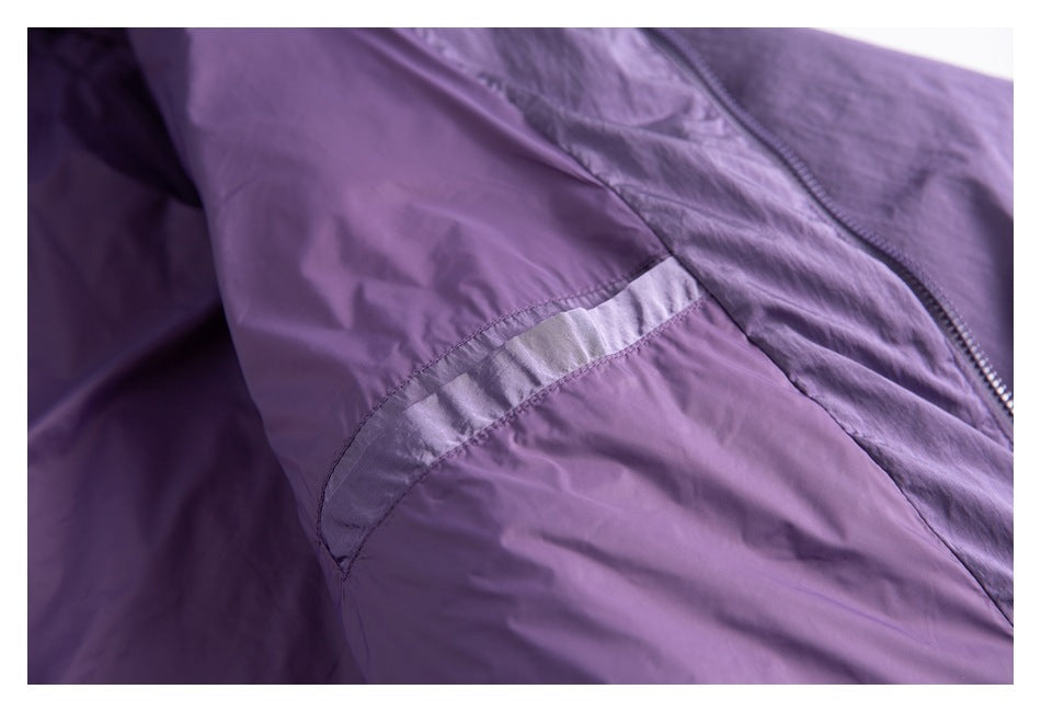 Close-up of a reflective-looking strip on the purple jacket sleeve beside the zipper.