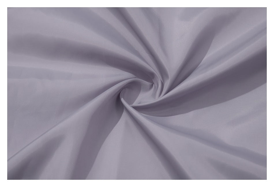 Pale lavender fabric twisted into folds to show its smooth surface and drape.
