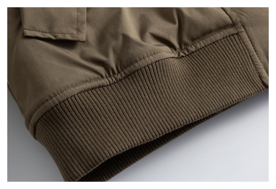 Close-up of the jacket's wide ribbed hem and gathered taupe-brown shell.