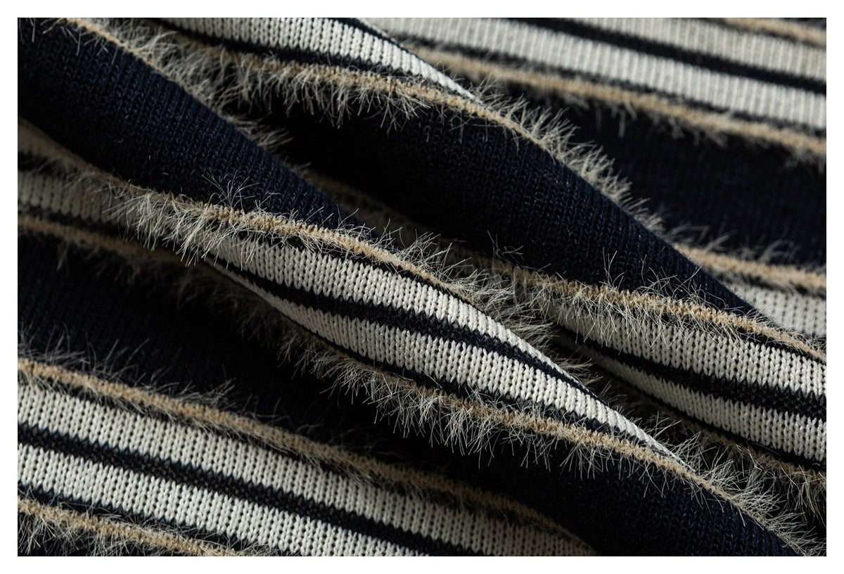 Macro view of navy and cream knit stripes with fuzzy beige yarn accents.