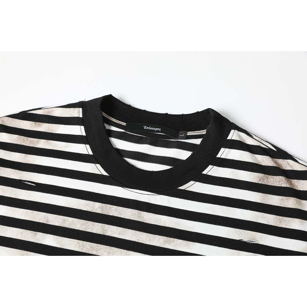 Close-up of a black ribbed crew neck and black-and-cream striped T-shirt with faded marks and small distressed slits.