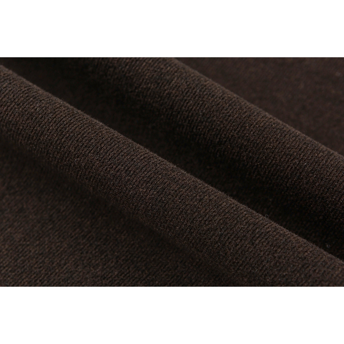 Macro close-up of the dark brown pants' knit surface and draped fabric.