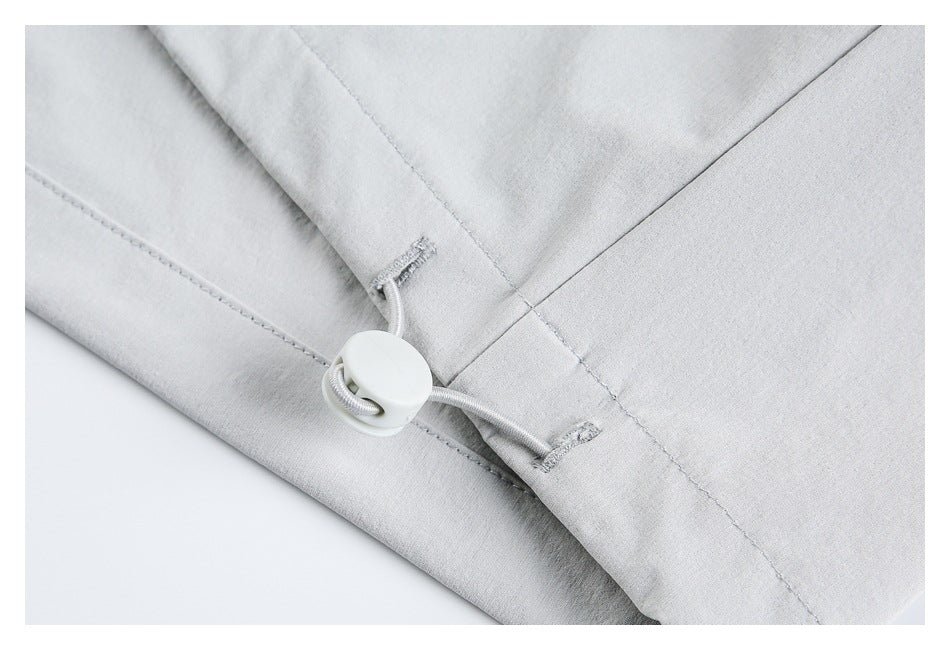 Close-up of the light gray jacket's adjustable hem cord and toggle.
