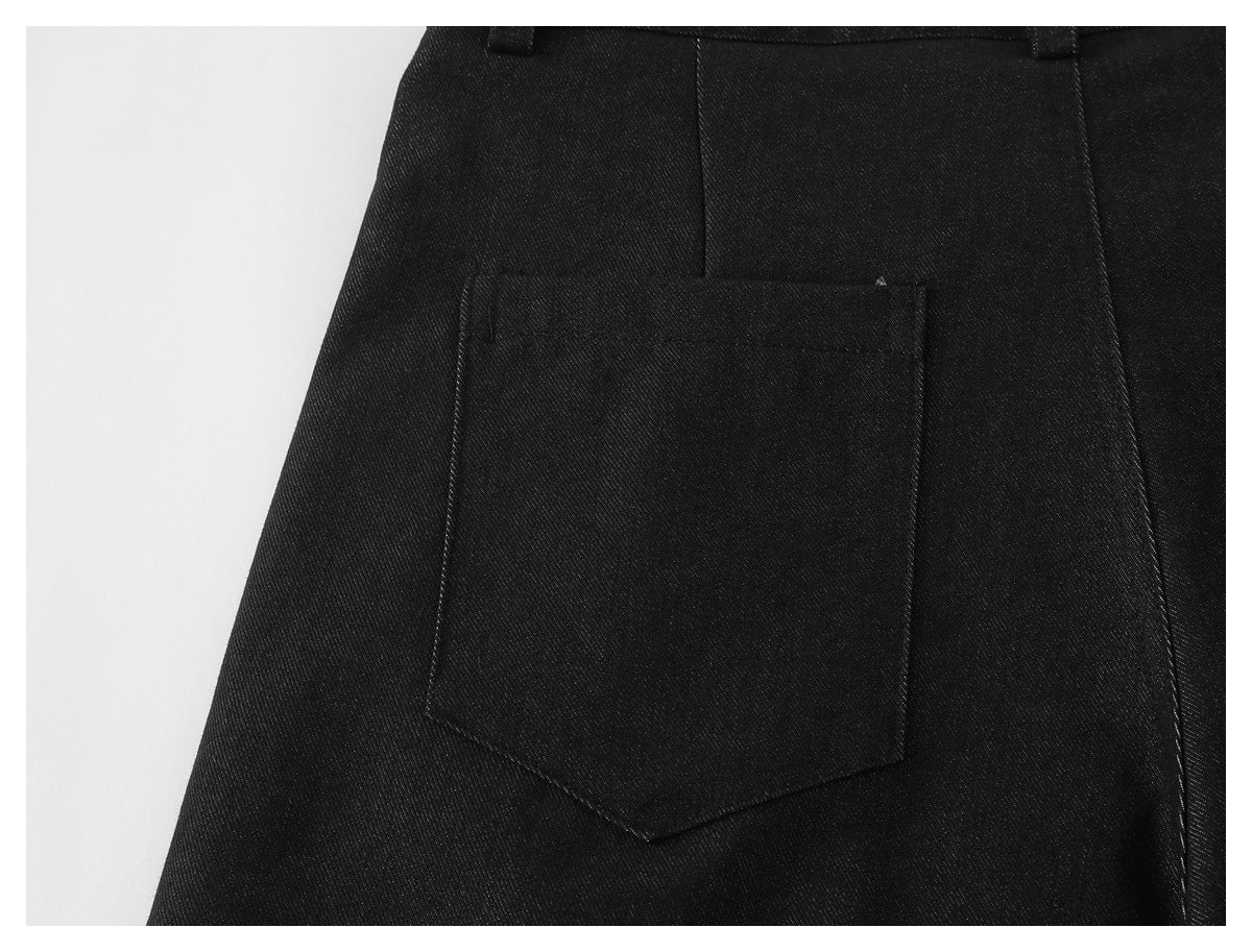 Close-up of black trousers showing a large rear patch pocket and belt loops.