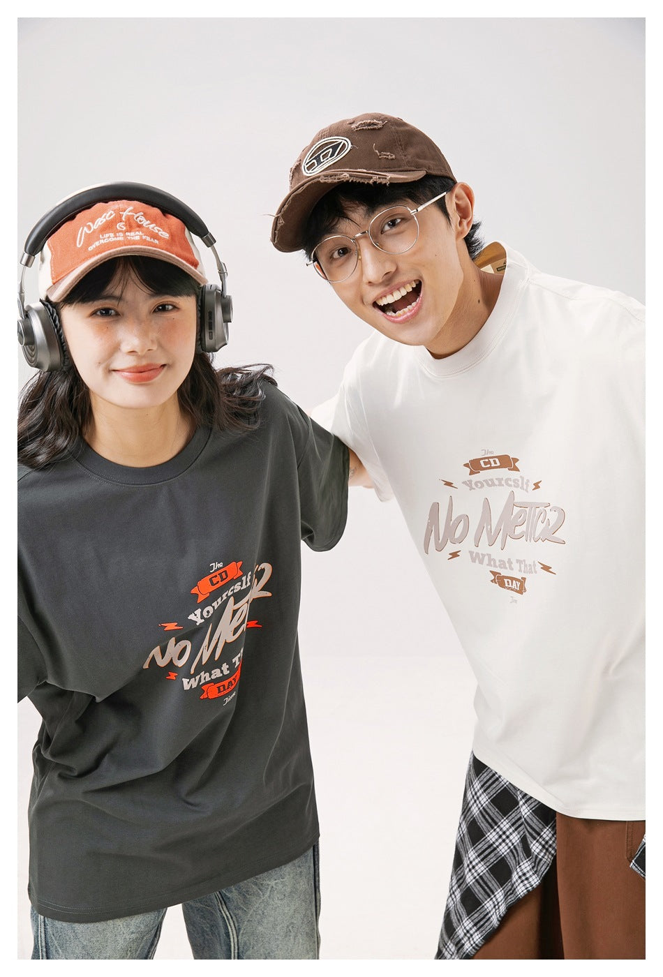 Close view of two models wearing charcoal and off-white oversized graphic T-shirts.