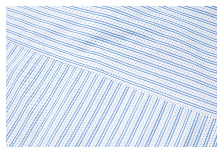 Close-up of a seam joining white fabric panels with fine blue stripes in different directions.