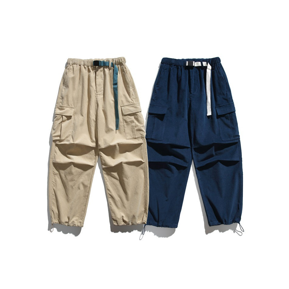Front view of cargo pants in beige and navy, both with elastic waists, belt straps, large flap pockets, and cuff drawcords.