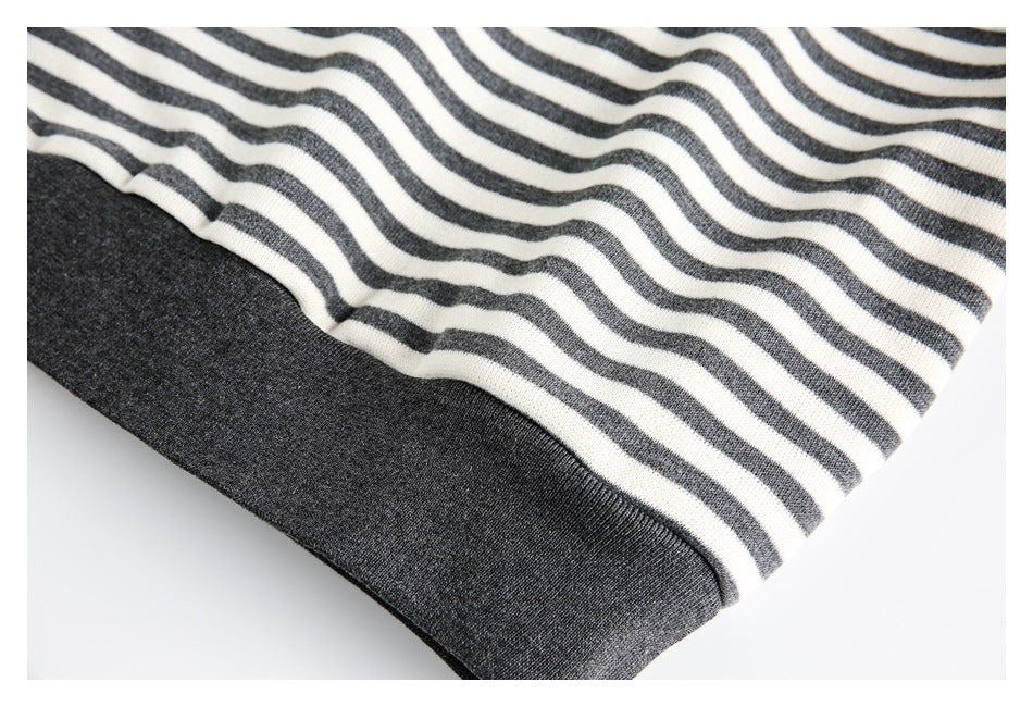 Close-up of cream and charcoal wavy stripes above a solid charcoal ribbed garment edge.