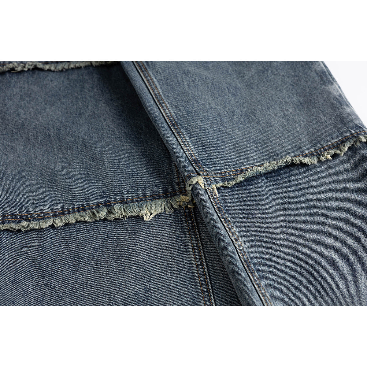 Close-up of blue-gray jeans showing a raw, frayed hem with visible seam stitching.