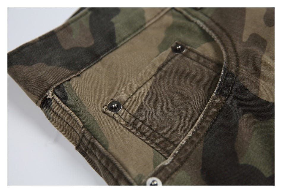 Close-up of a small front pocket with metal rivets on camouflage trousers.