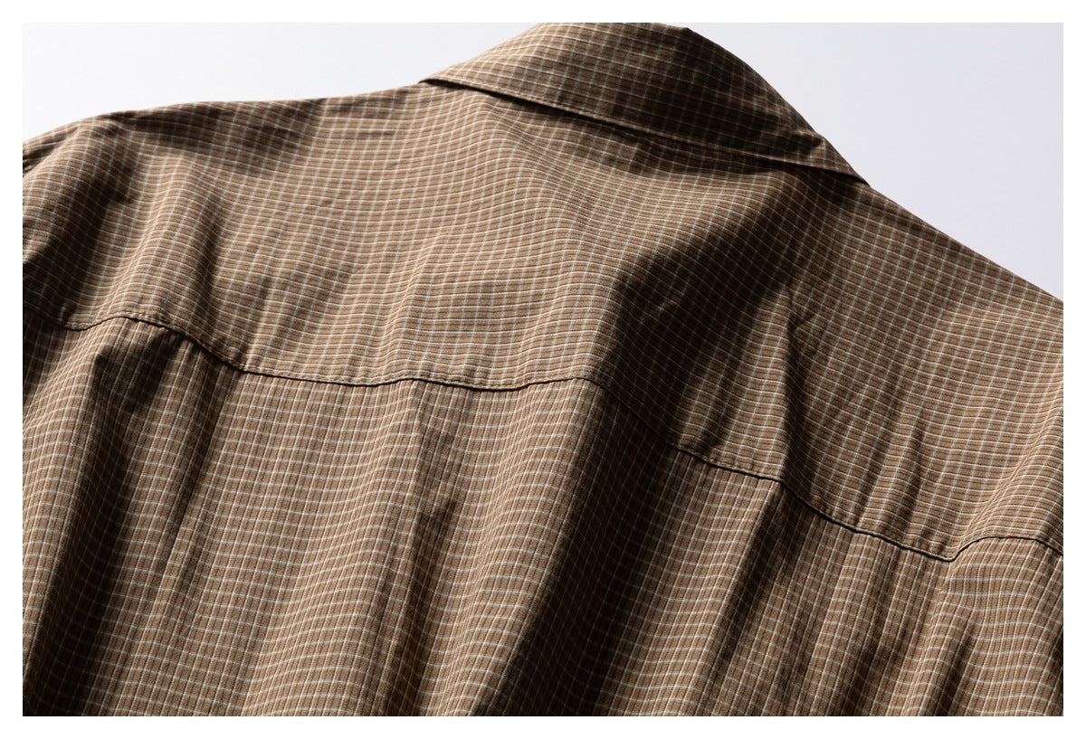 Close-up of a brown checked garment showing the collar and curved back yoke seam.