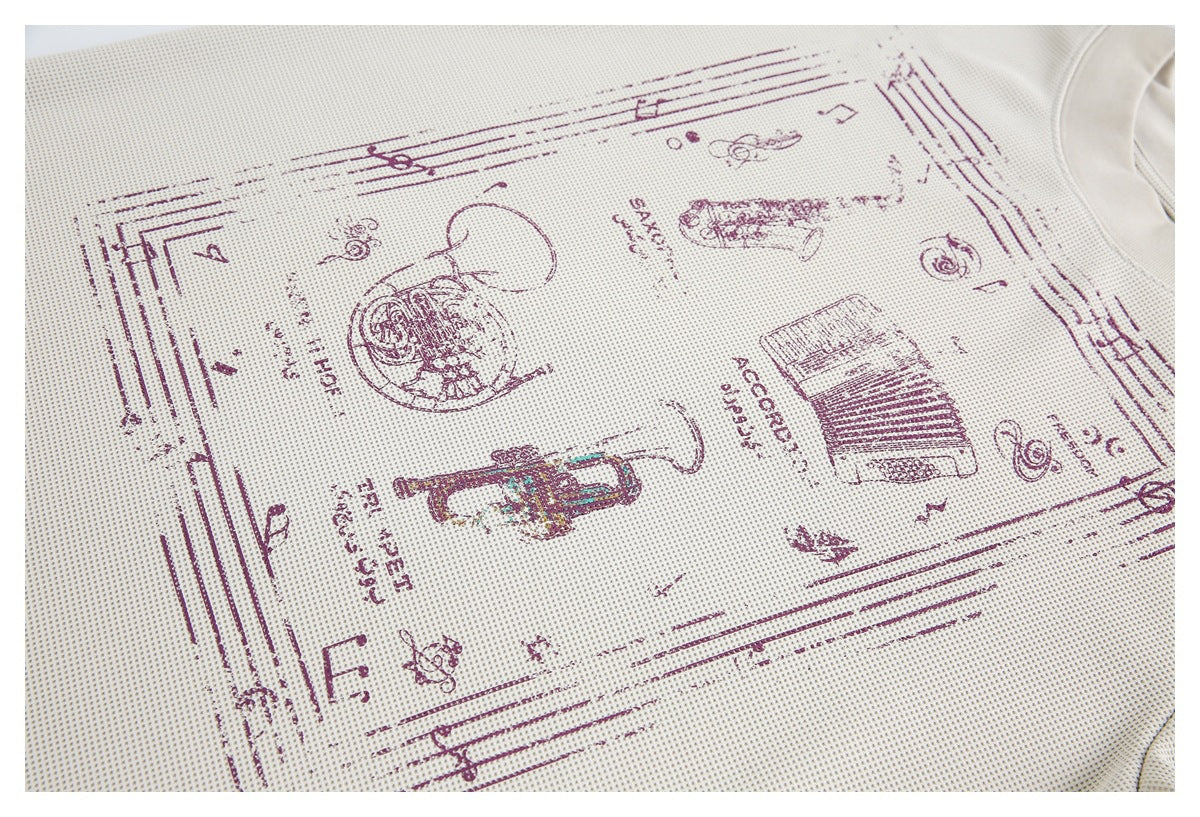 Close-up of an off-white textured shirt with a burgundy vintage music-themed graphic and part of the neckline.