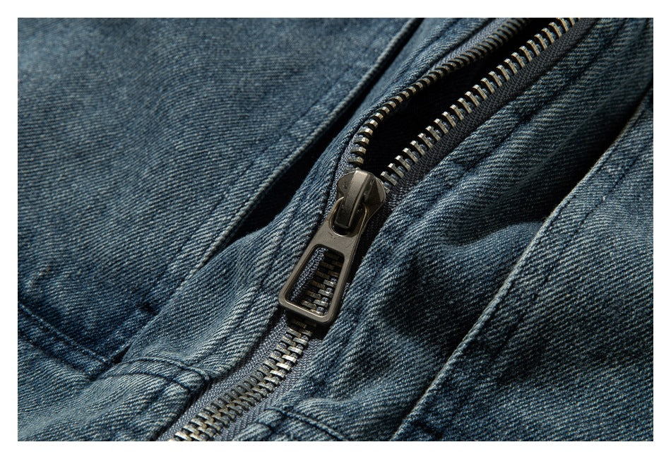Close-up of the jacket's metal zipper set into blue denim fabric.