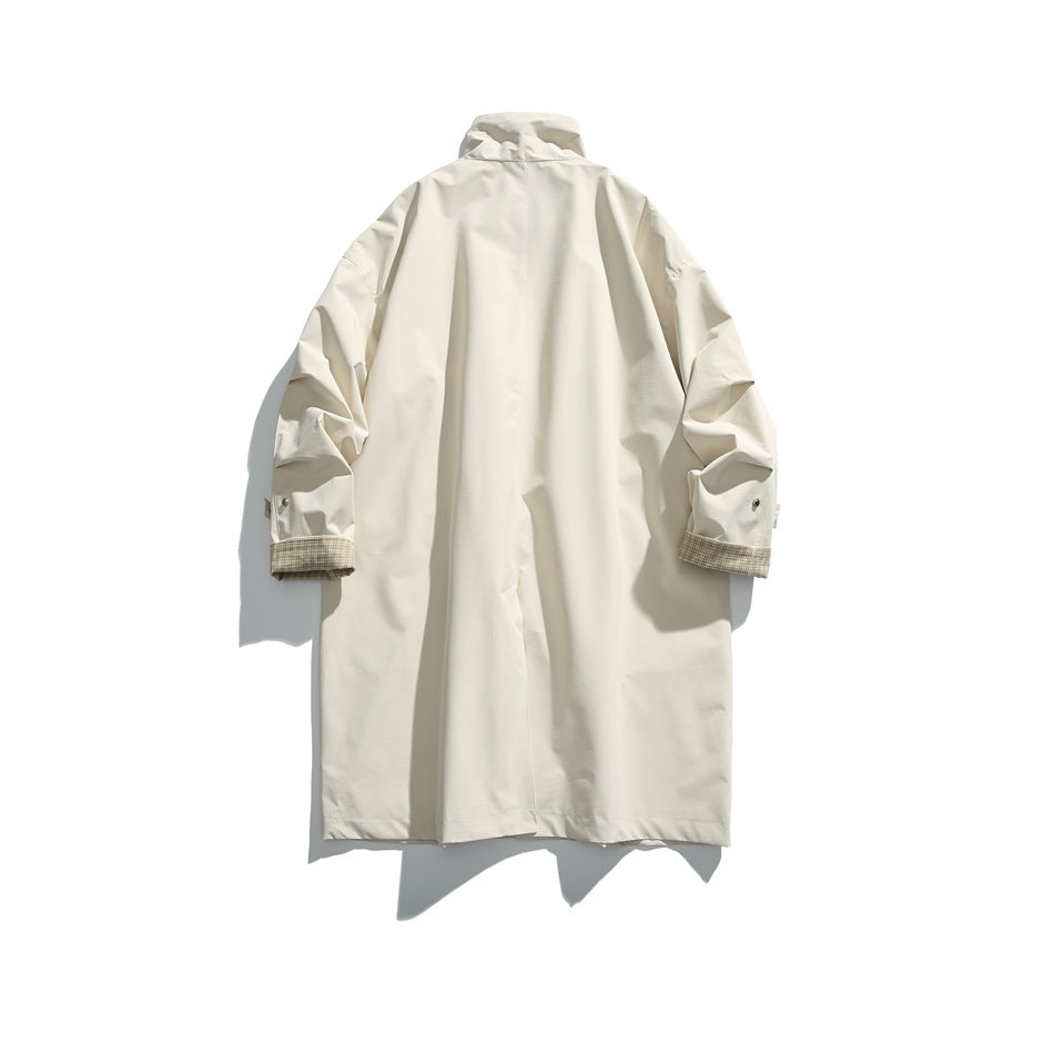 Back view of an ivory long coat with a high collar and plaid lining showing at the turned-back cuffs.