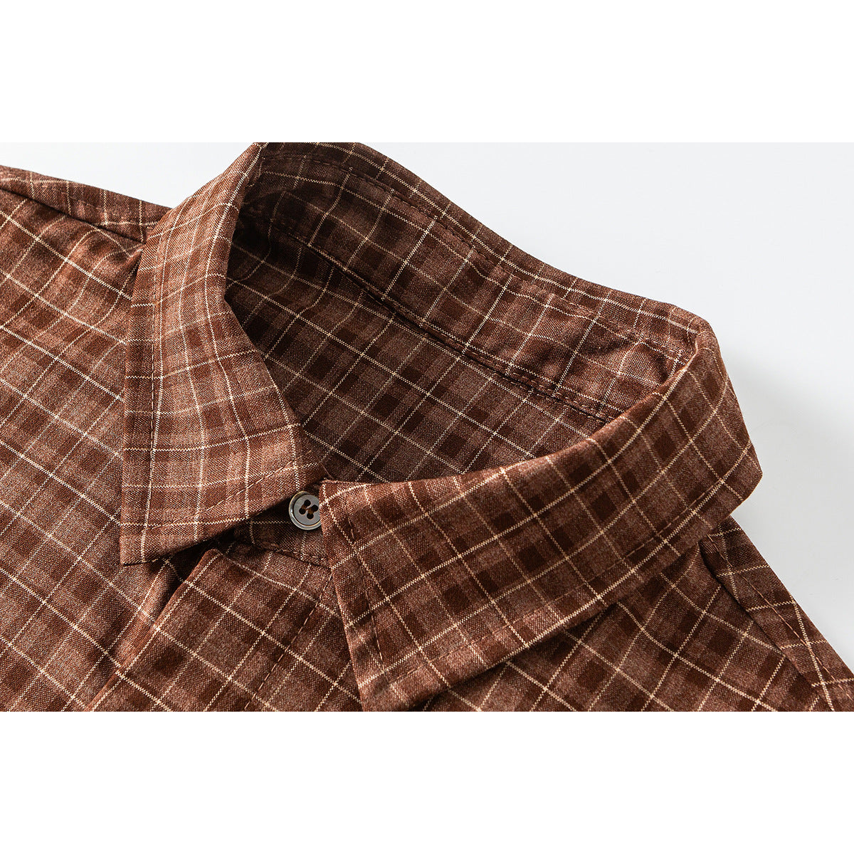 Close-up of a brown plaid shirt collar, button, stitching, and fabric.