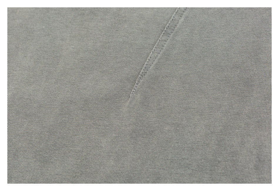 Close-up of gray knit fabric with a curved stitched seam.