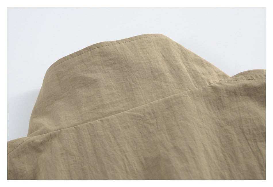 Close-up of a tan jacket's back yoke seam and shoulder area.