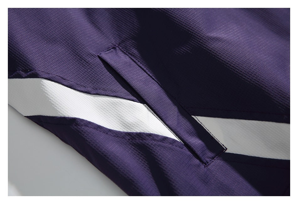 Close-up of a purple textured jacket with a white diagonal stripe and a narrow stitched tab.