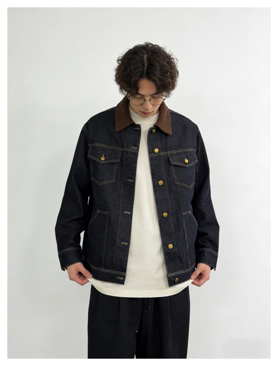 Model wearing a dark indigo denim jacket with a brown collar, contrast stitching and brass-tone buttons.