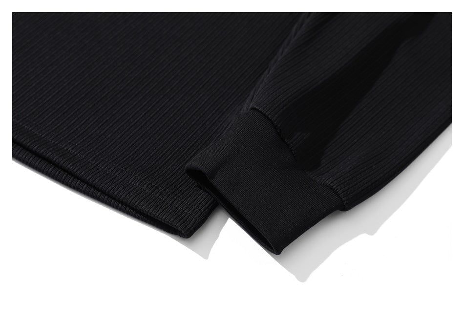 Close-up showing a black ribbed sleeve ending in a wide, smooth cuff.