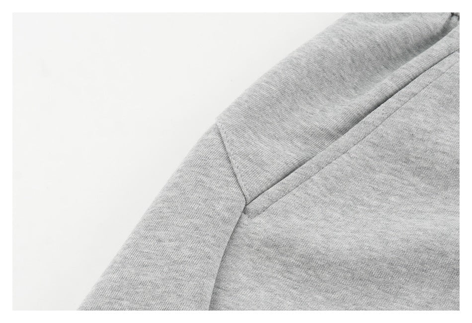 Close-up of light gray sweatpants fabric and angled pocket seam.