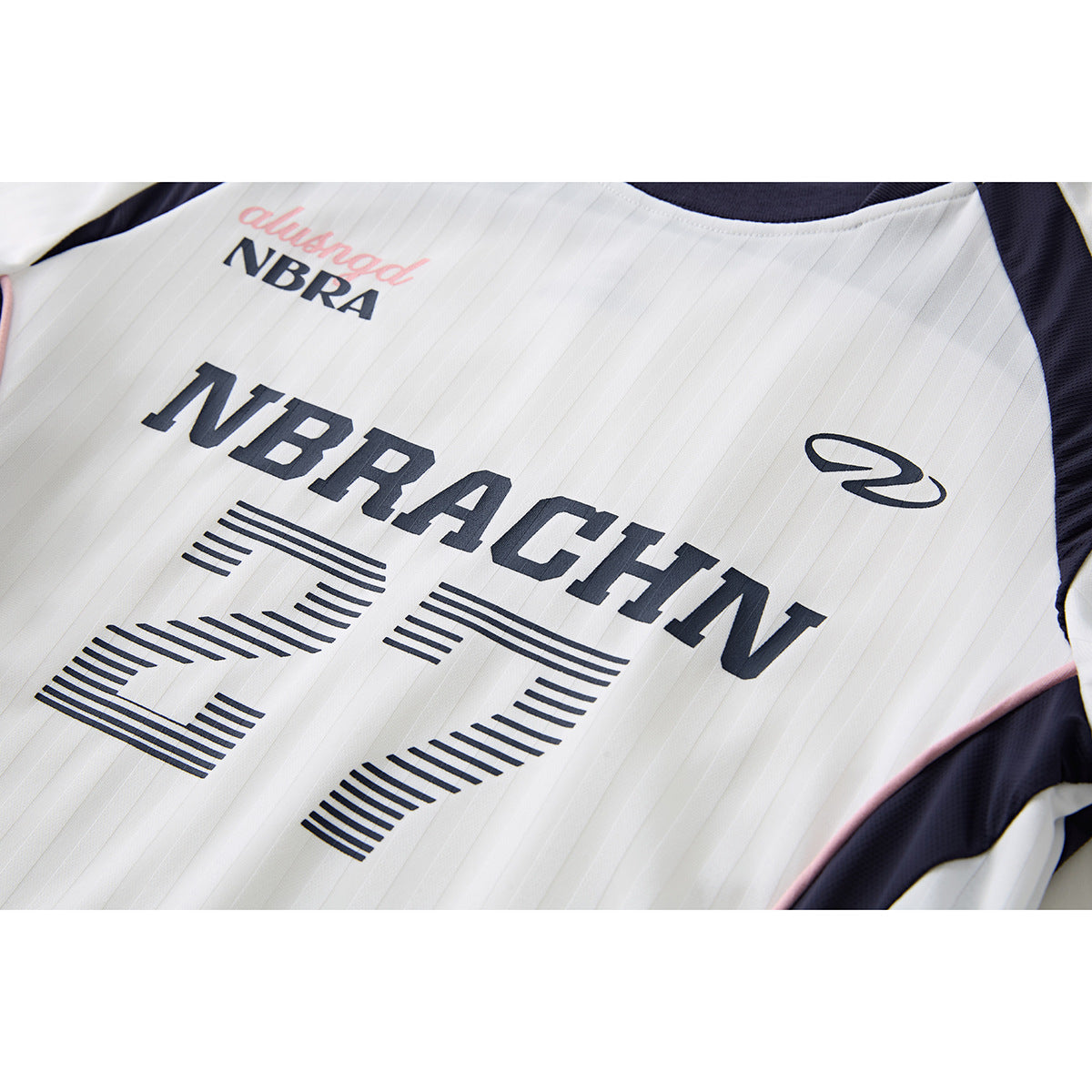 Close-up of a white pinstriped jersey front with navy lettering, a stylized number 27, and navy side panels.