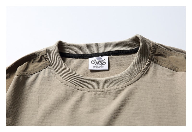 Close-up of the taupe pullover's ribbed crew neck, shoulder panel and sewn-in brand label.