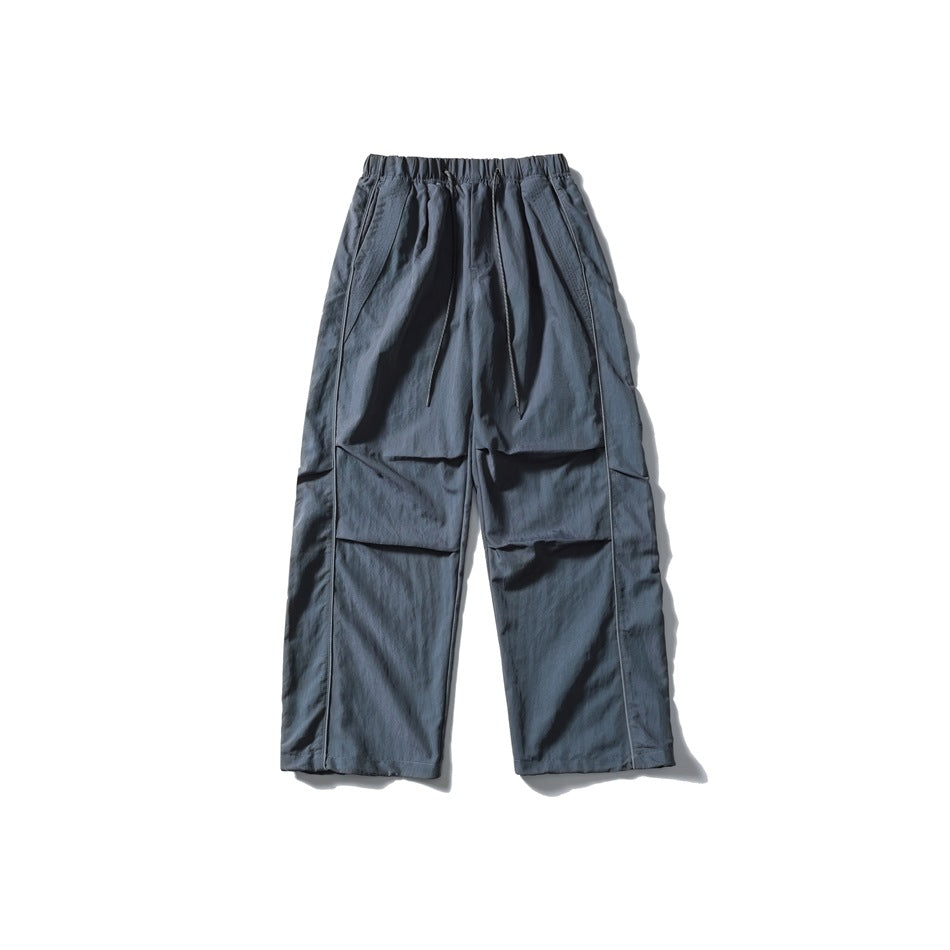 Blue-gray relaxed cargo pants with an elastic drawstring waist, angled pockets, large flap pockets and straight hems.