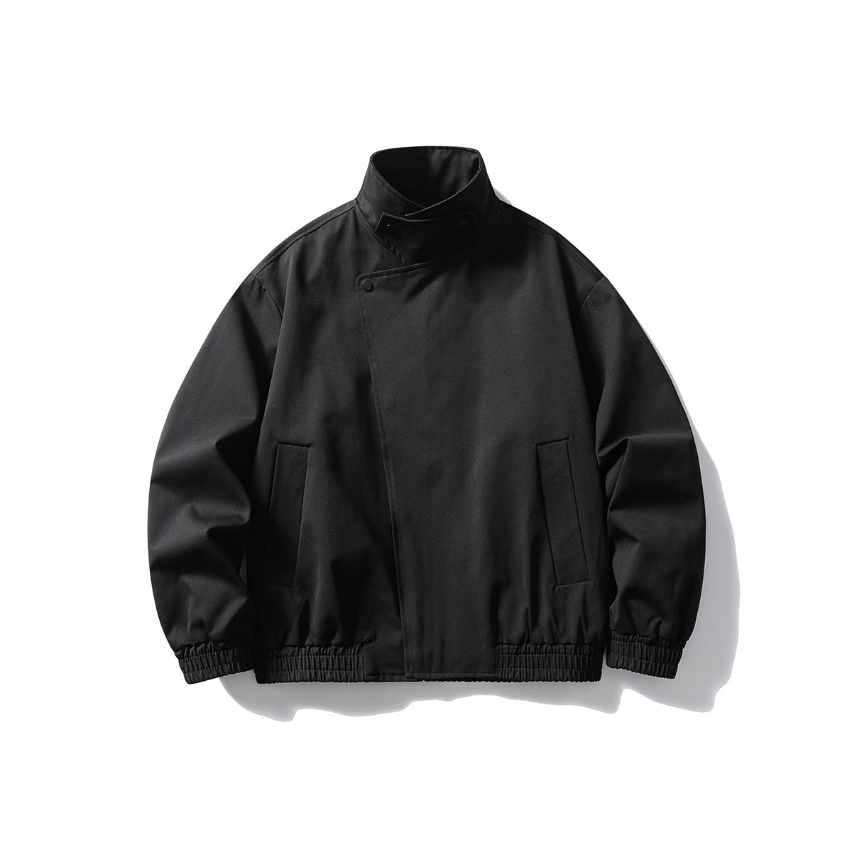 Black stand-collar jacket with diagonal snap front, vertical pockets and elastic cuffs and hem, flat lay