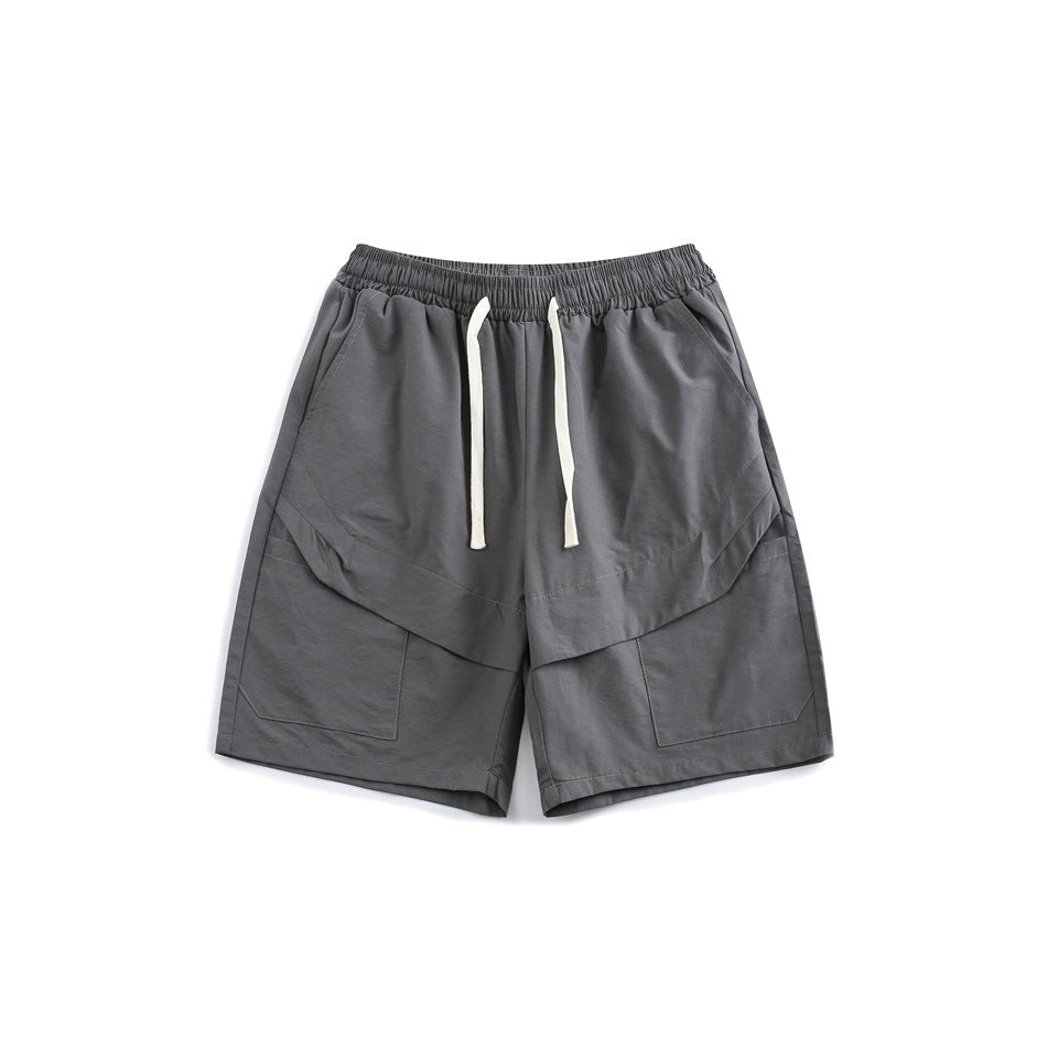 Gray knee-length shorts with elastic waistband, white drawstring and large front patch pockets, flat lay front view