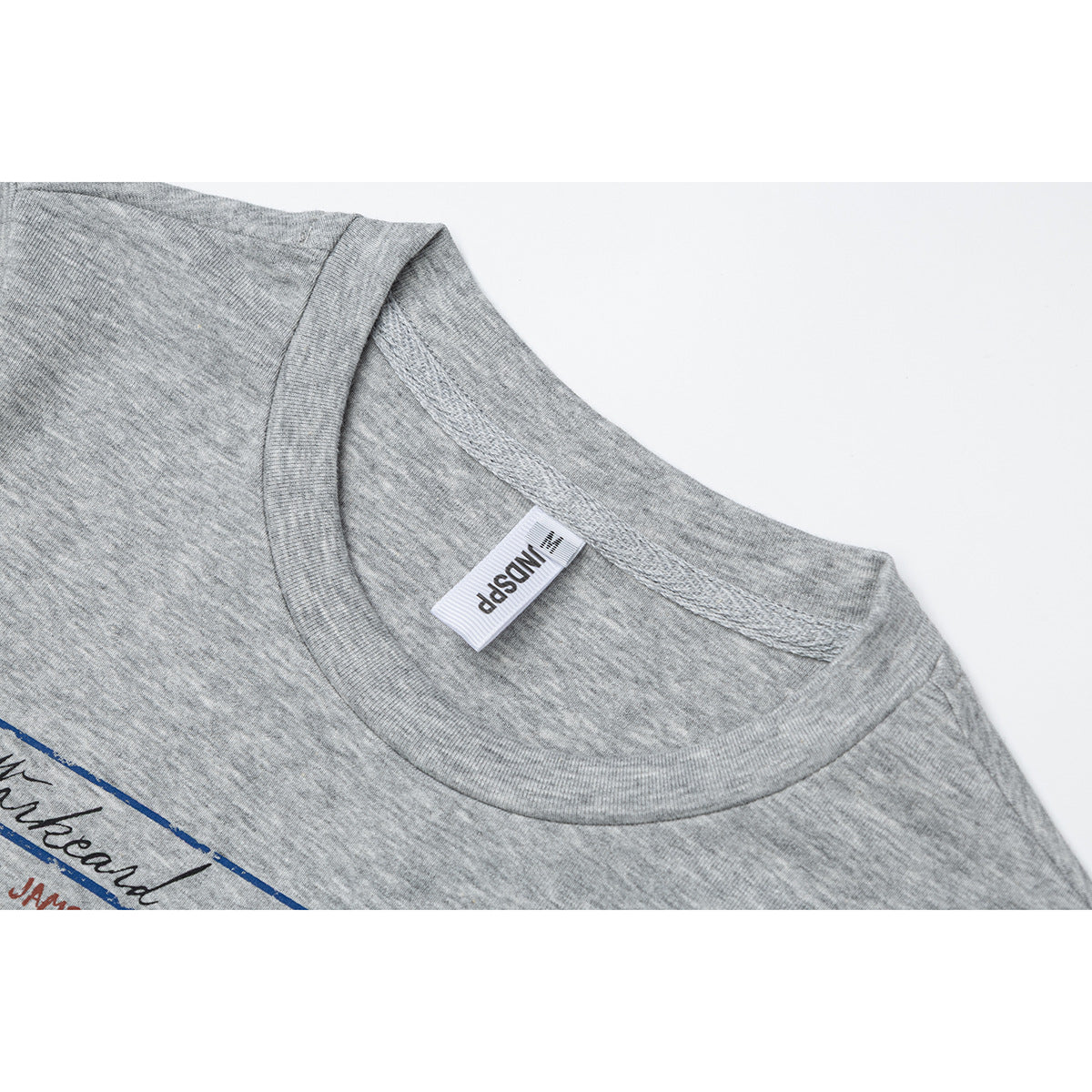 Close-up of a gray crew-neck T-shirt showing the ribbed neckline, inner label and part of its printed graphic.